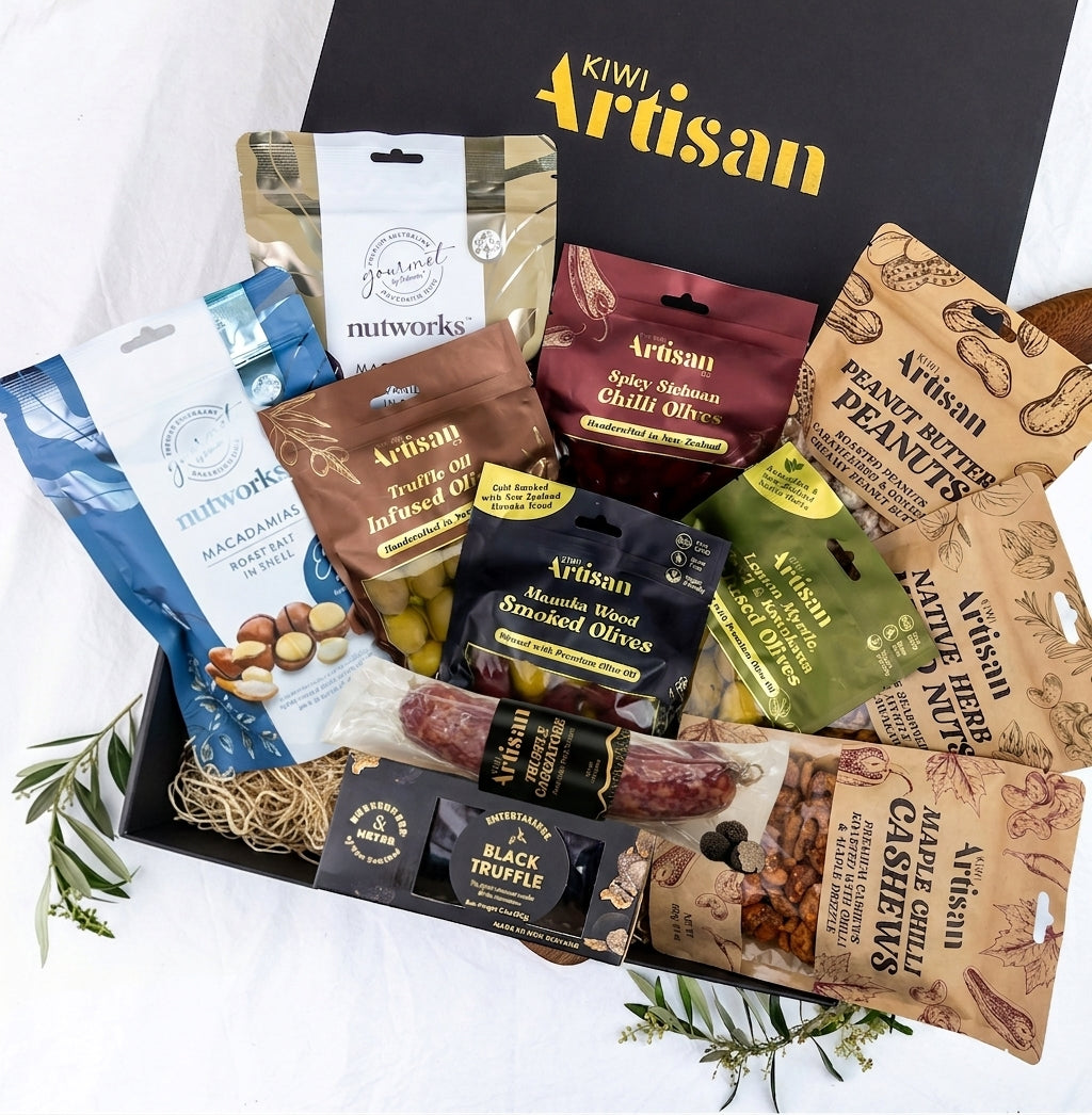Assorted gourmet snacks in a 'Kiwi Artisan' box on a white background