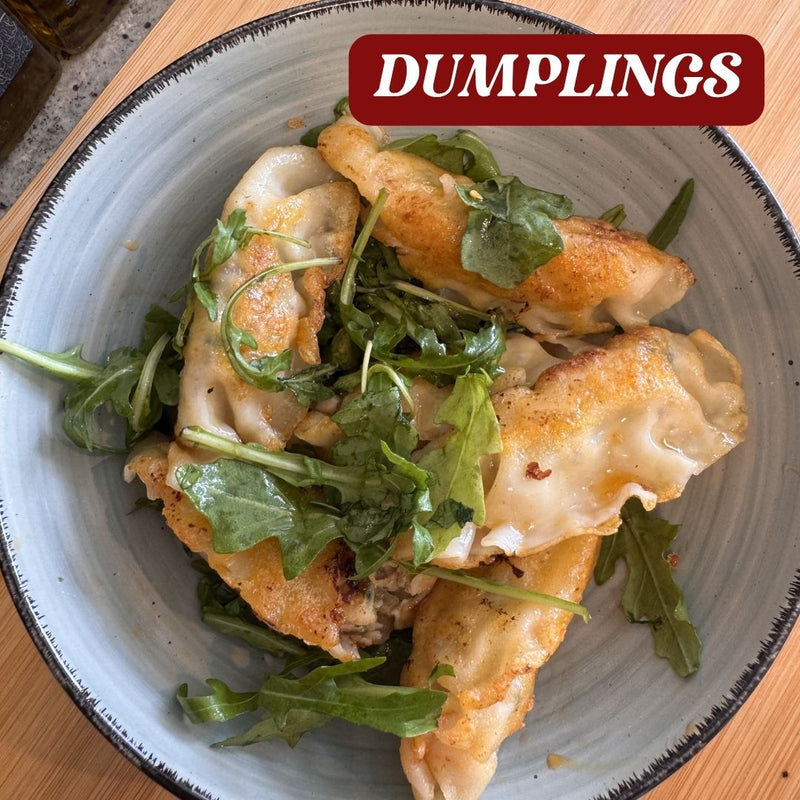 Dumplings with greens on a gray plate, labeled 'Dumplings' at the top.