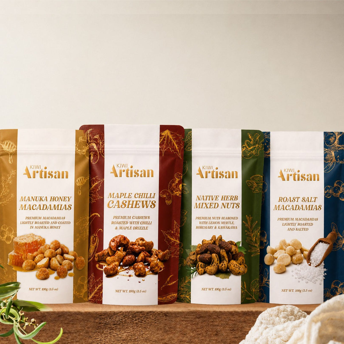 Assorted packages of 'Kiwi Artisan' nut products on a wooden surface with a neutral background.