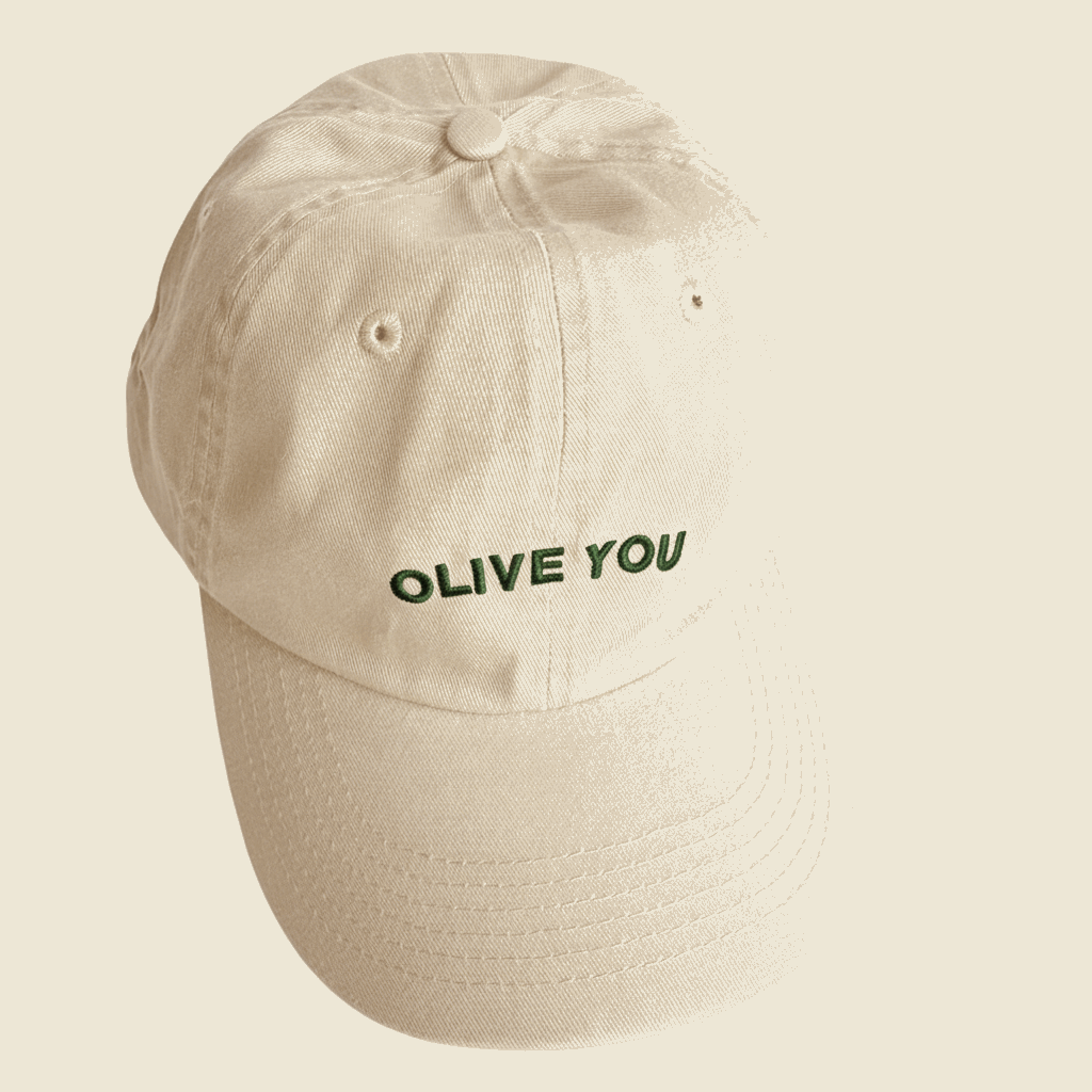 Beige cap with 'OLIVE YOU' text on a beige background