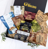 Assorted food items in a 'Kiwi Artisan' box on a white background