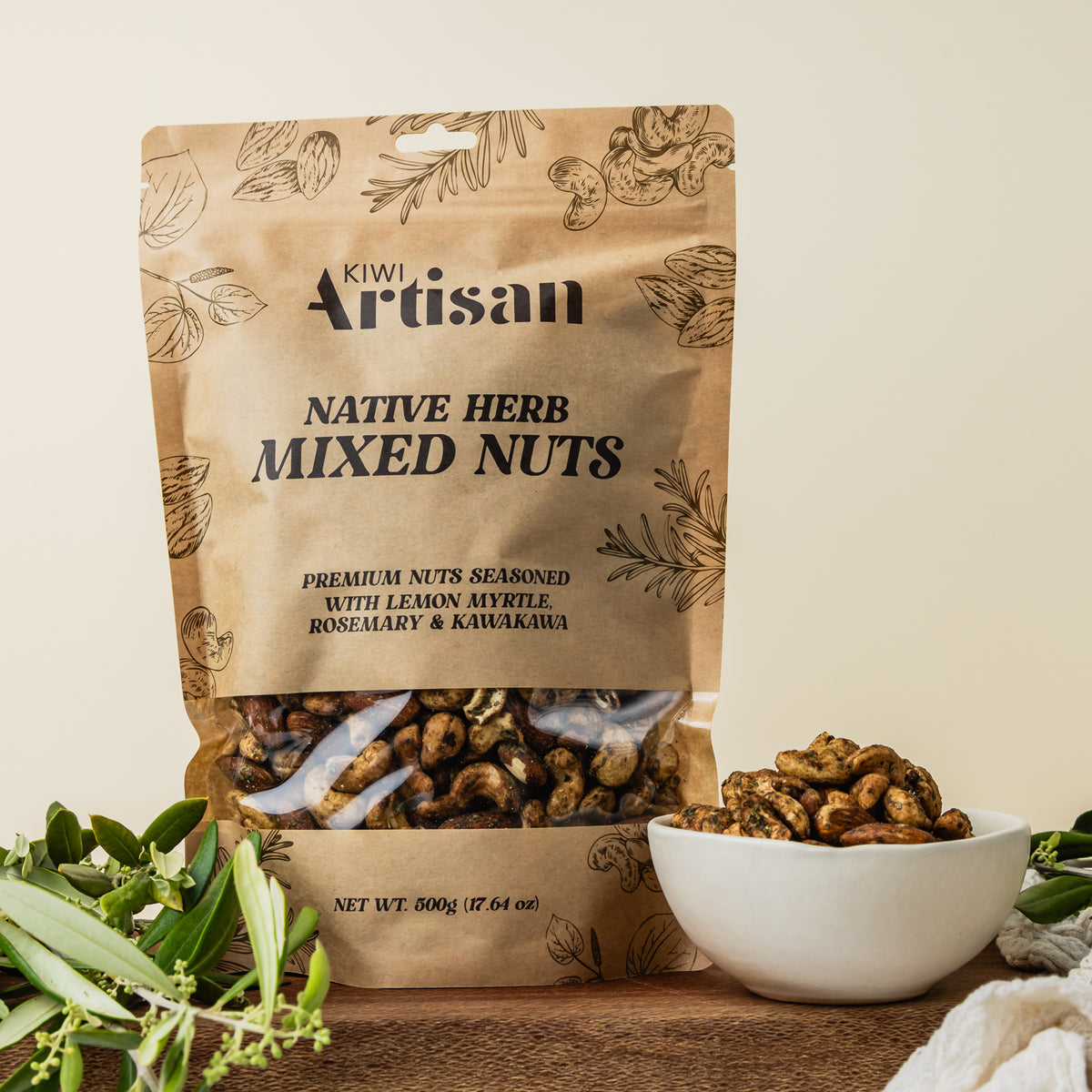 Kiwi Artisan Native Herb Mixed Nuts packaging with a bowl of nuts on a wooden surface.