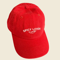 Red cap with 'Spicy Lover' text and chili pepper graphic on a beige background
