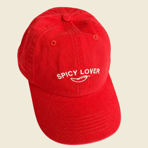 Red cap with 'Spicy Lover' text and chili pepper graphic on a beige background