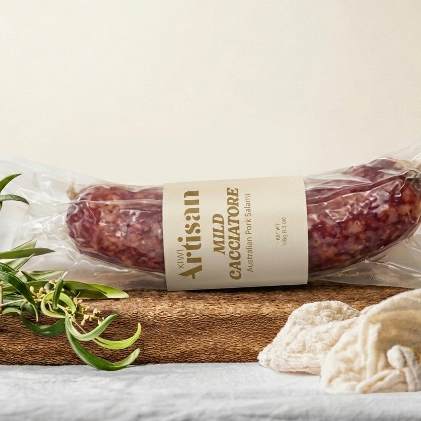Packaged salami with a label on a wooden board