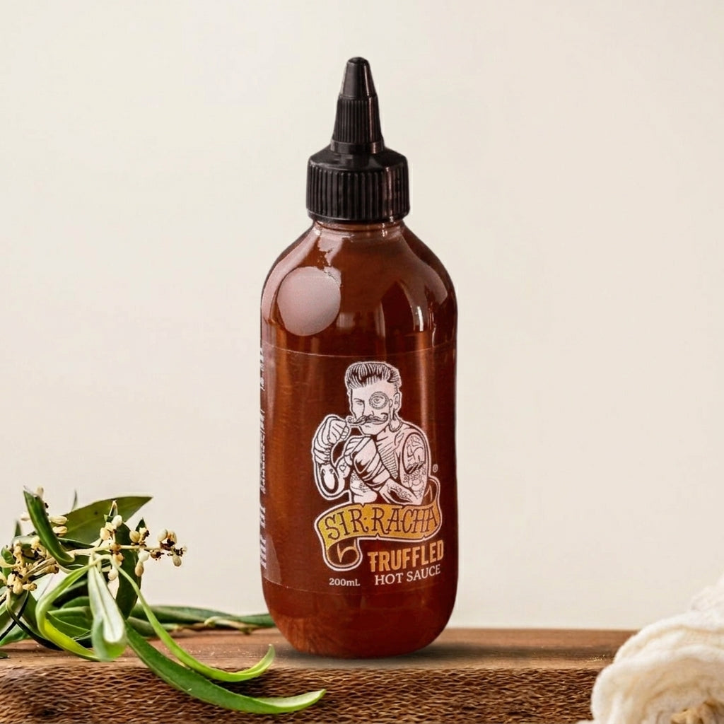 Bottle of Siracha Truffled Hot Sauce on a wooden surface with a light background