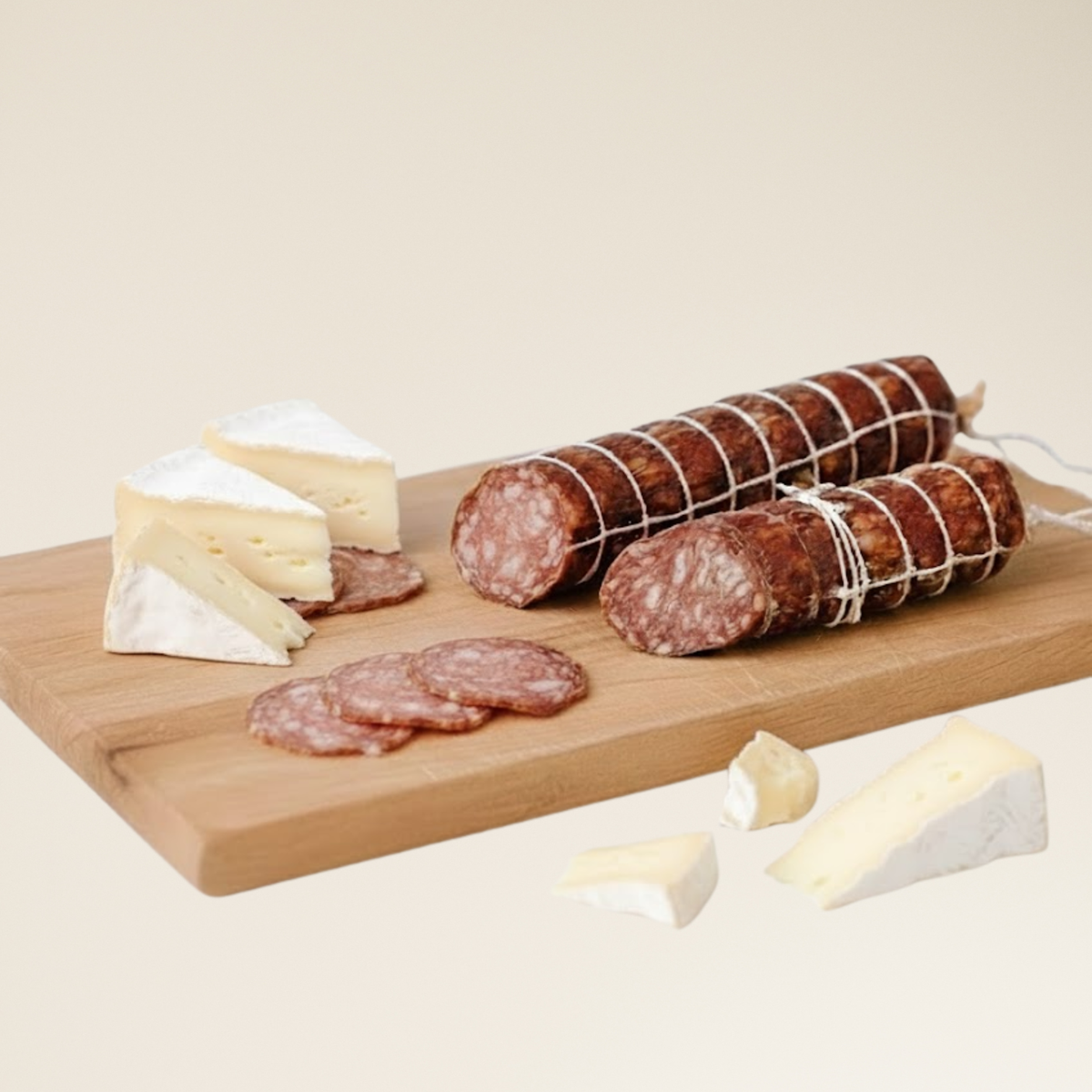 Wooden cutting board with sliced truffle dry aged salami and cheese on a beige background